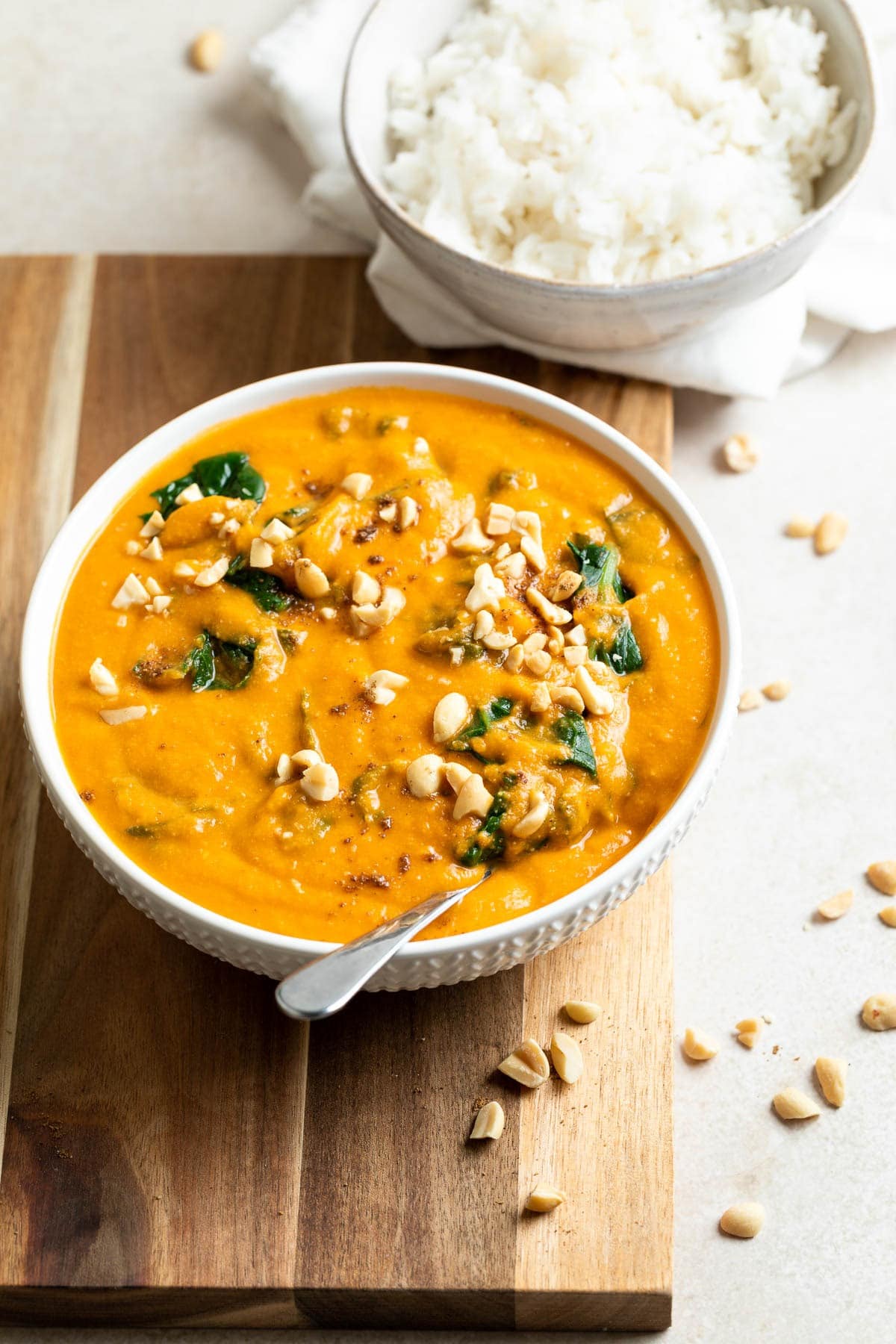 Domoda stew in a bowl topped with chopped peanuts.