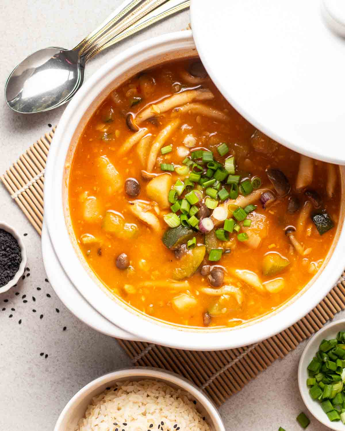 Large soup pot with lid partially on, full of gochujang stew.