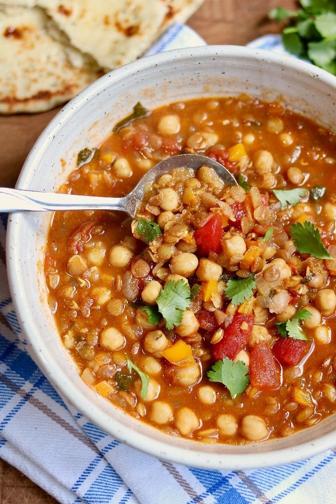 Bowl of moroccan stew with a spoon scooping some up.