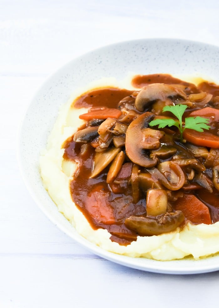 Bowl of mashed potatoes topped with Scottish mushroom stew.