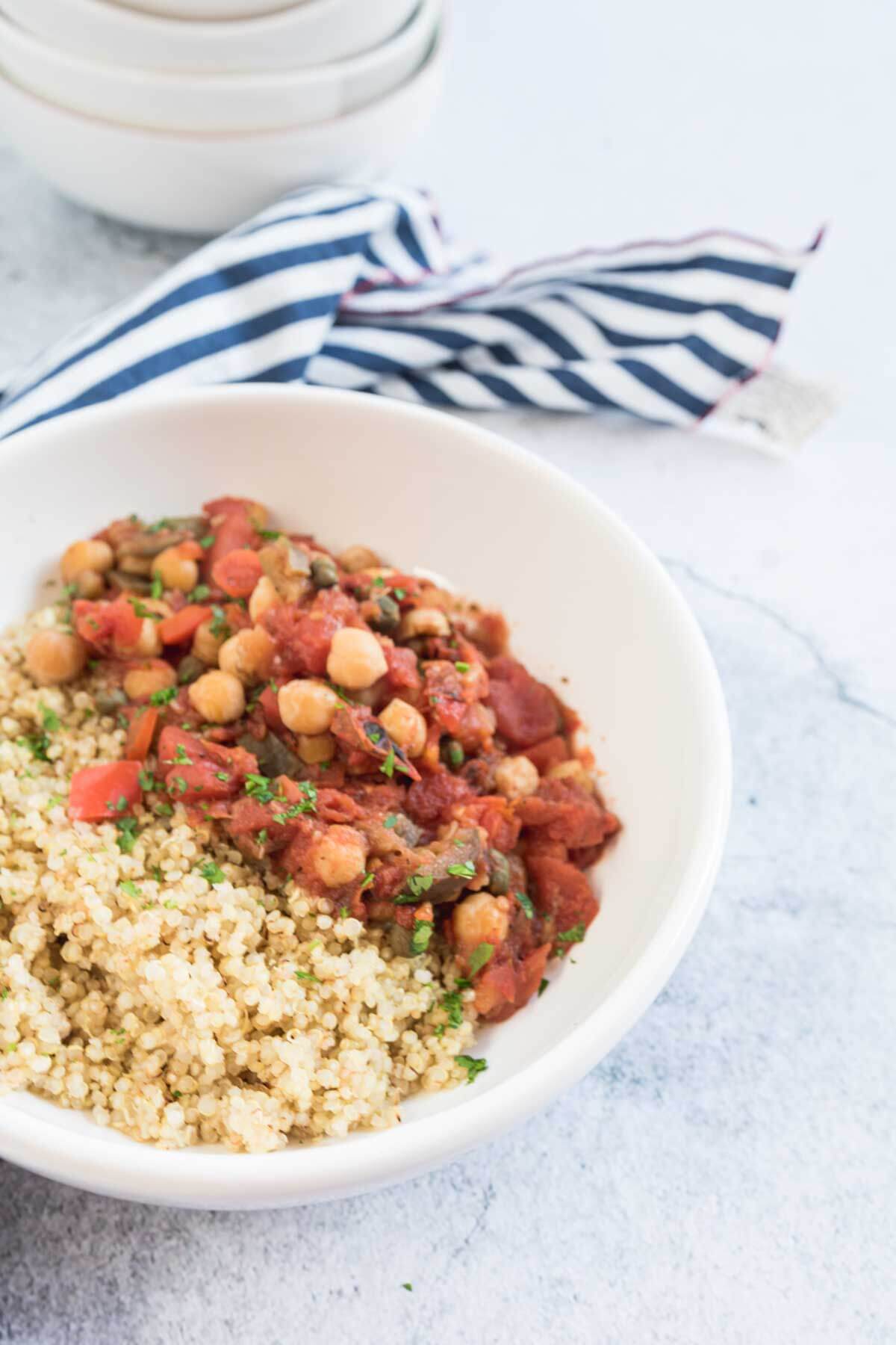 Bowl of eggplant stew serve with quinoa.