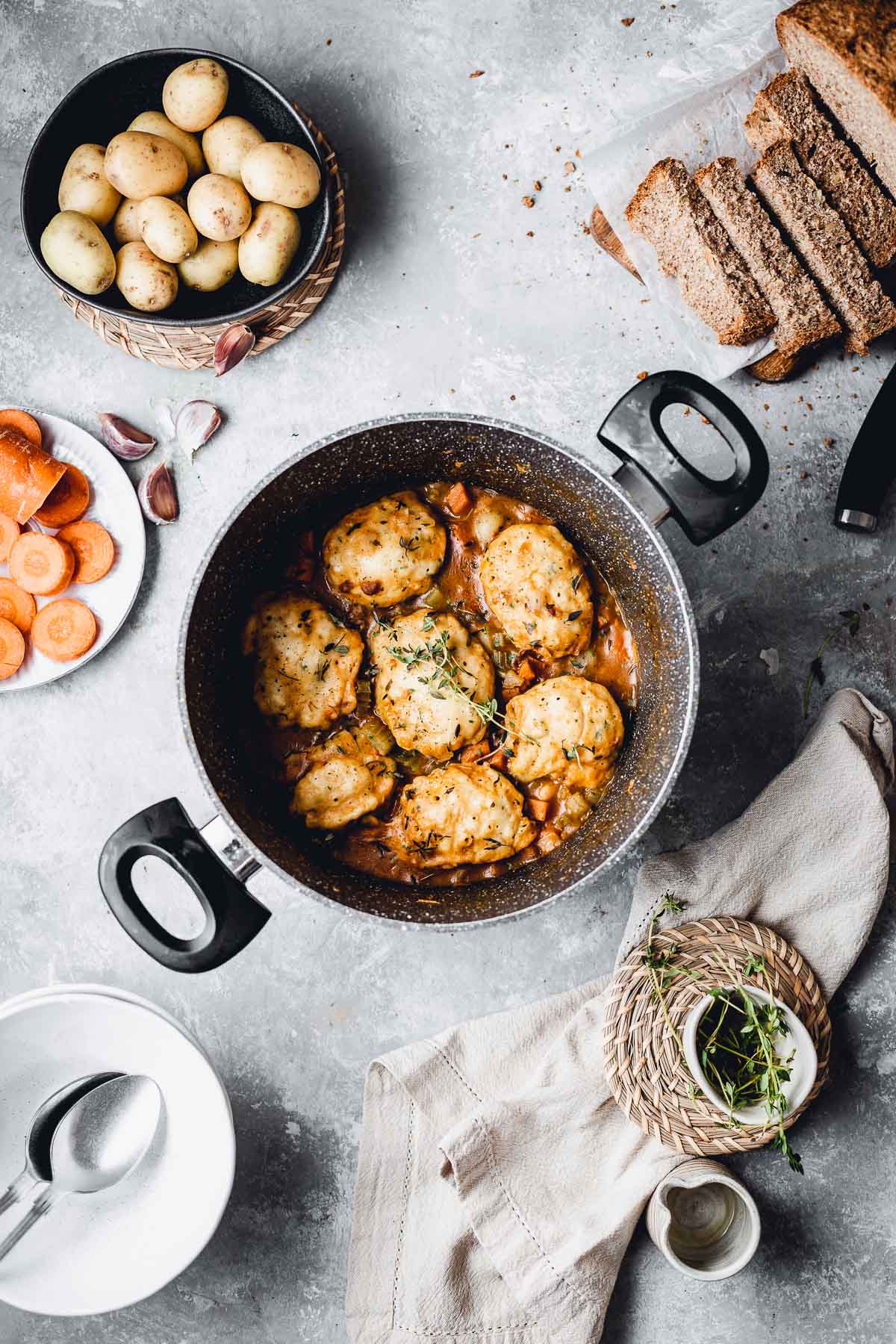Large soup pot filled with vegan stew and topped with dumplings.