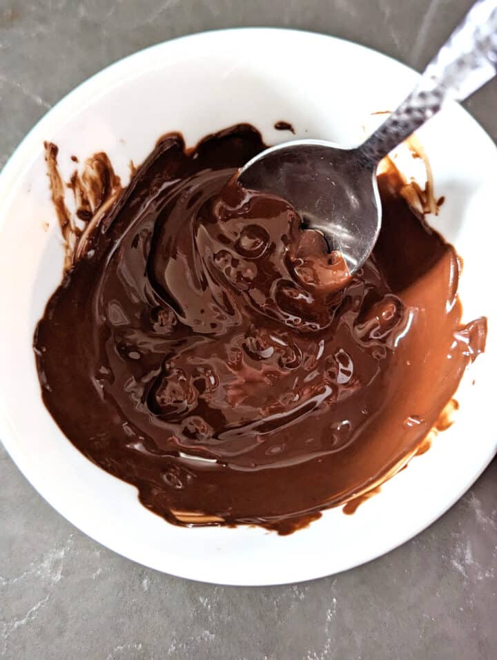 Dark chocolate that has been almost melted with a few lumps remaining.