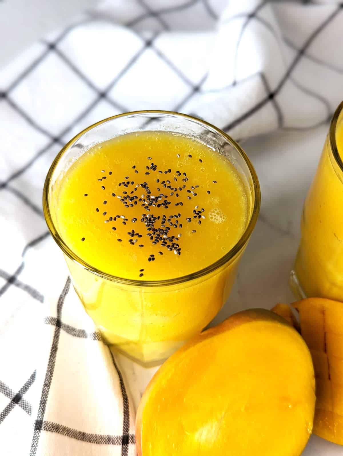 Glass of mango juice topped with chia seeds.