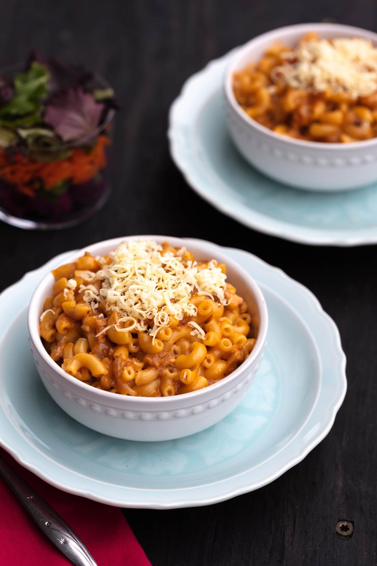 Bowls of hamburger helped topped with shredded vegan cheese.