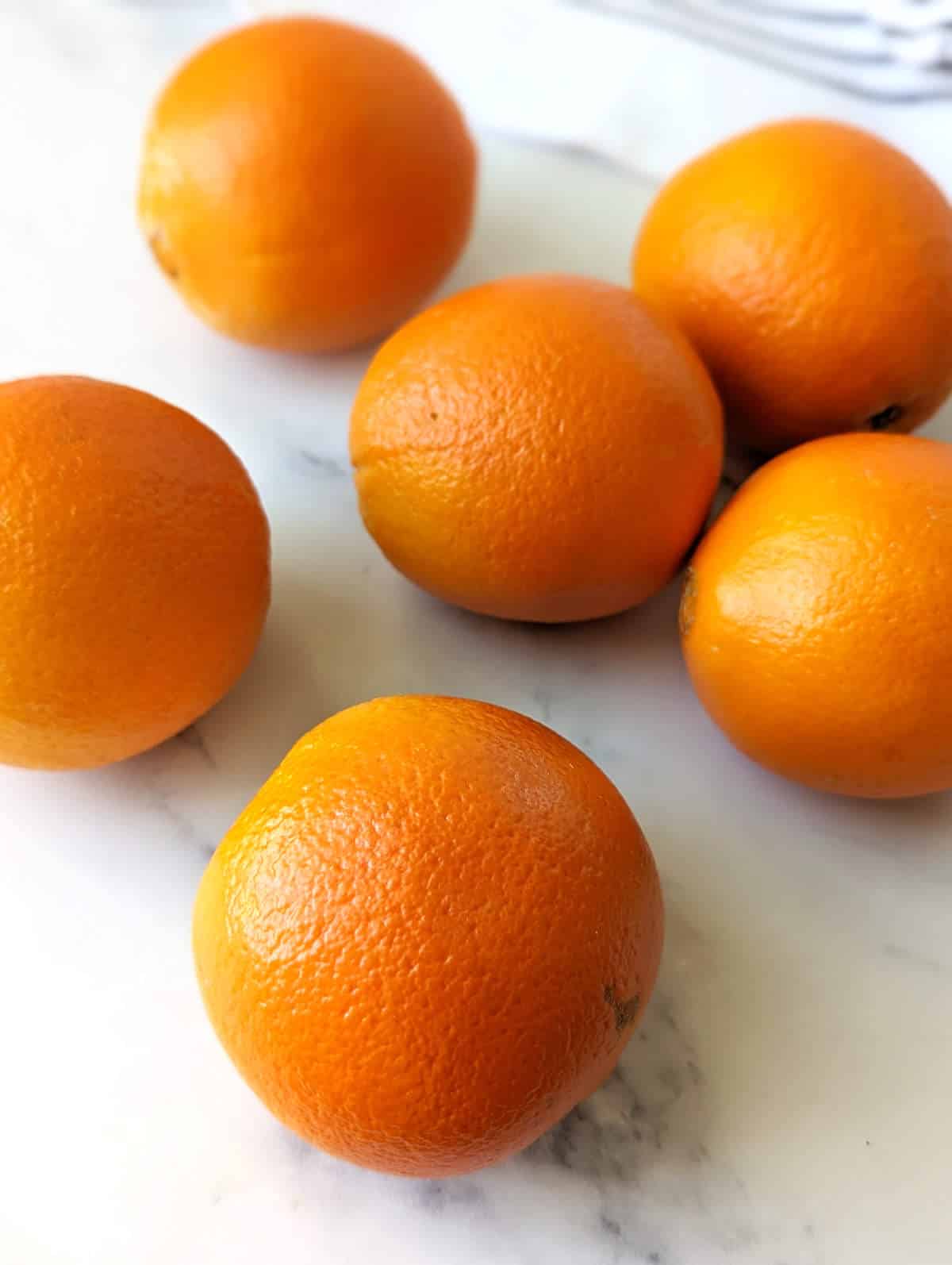 Several navel oranges on a light background.