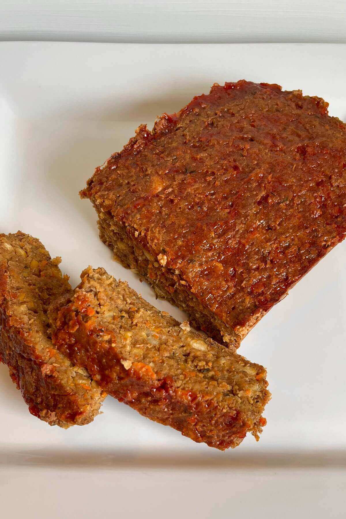 Vegan meatloaf with a couple pieces sliced off.