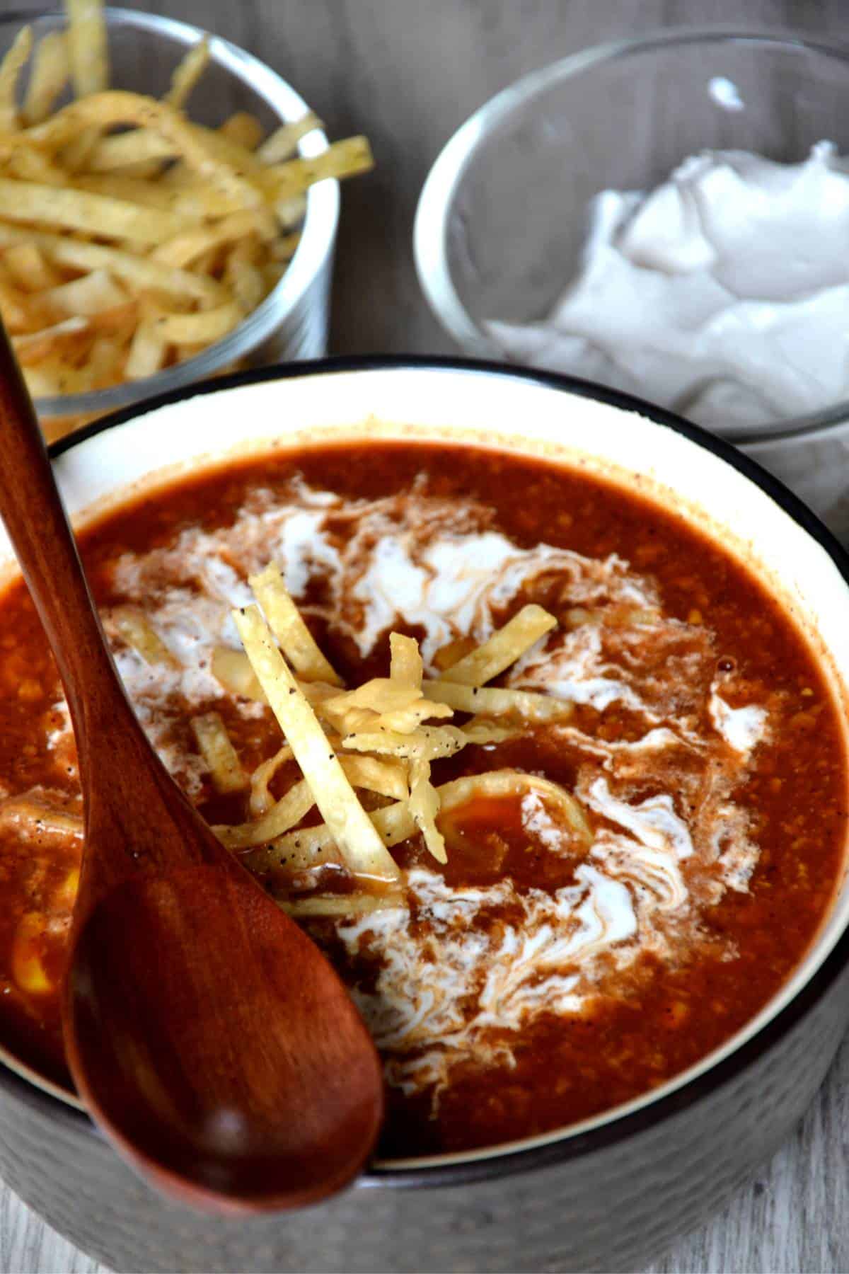 Vegan taco soup topped with tortilla chip slice and a spoon.