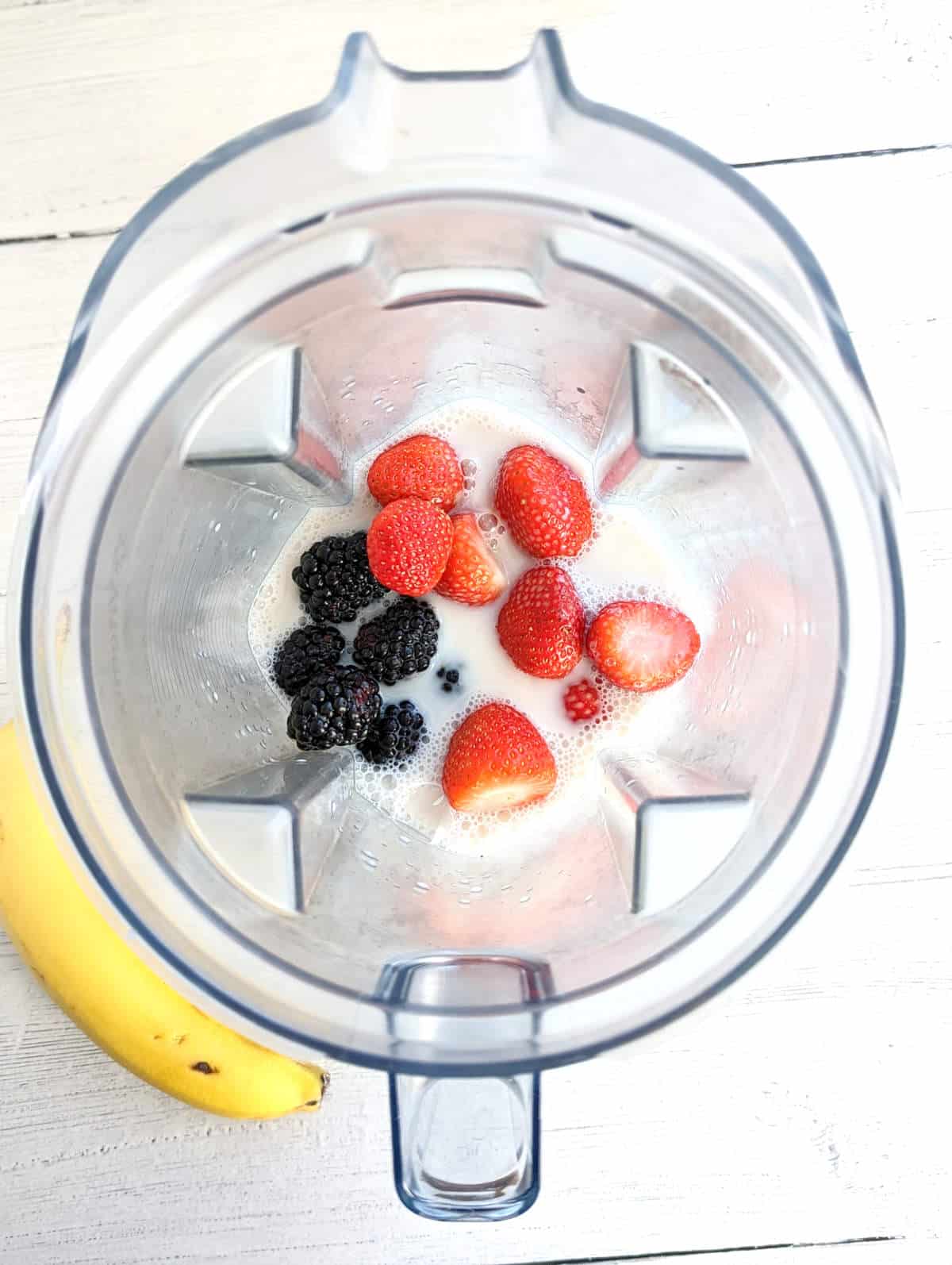 Milk and berries in blender.