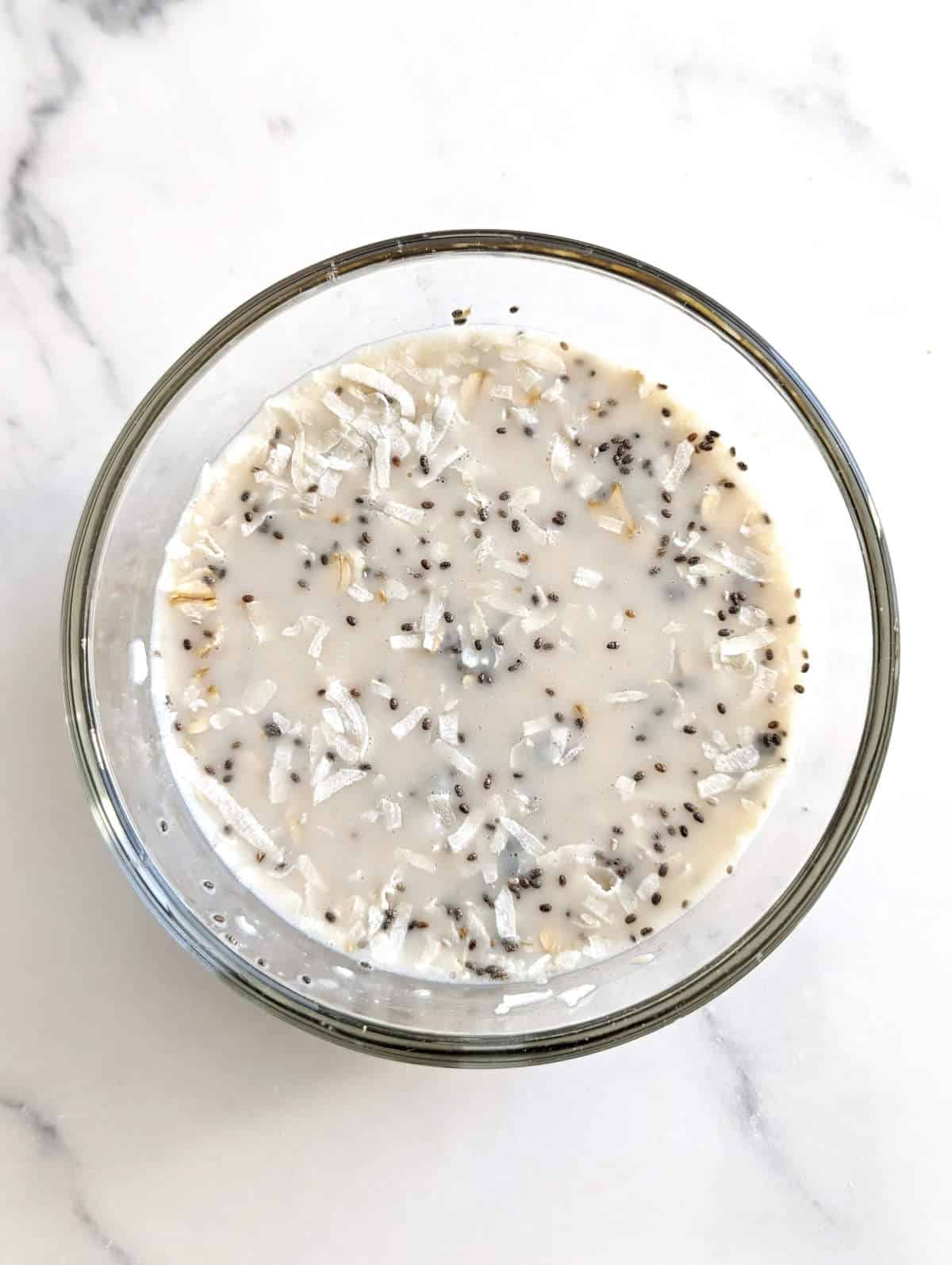Coconut milk overnight oats ingredients mixed together in a bowl.
