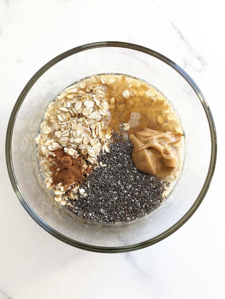 Ingredients for overnight oats with water in a bowl before mixing.