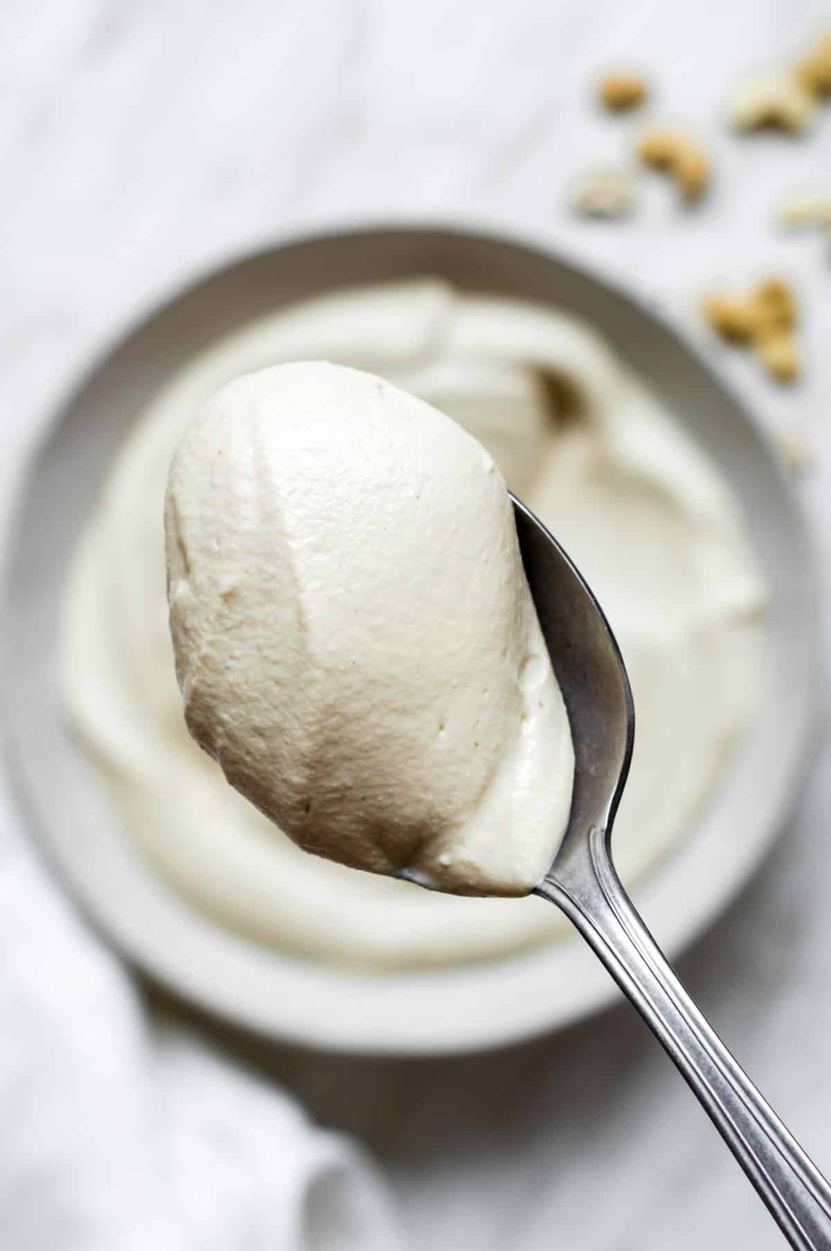 A close-up shot of a spoon full of vegan mascarpone cheese.