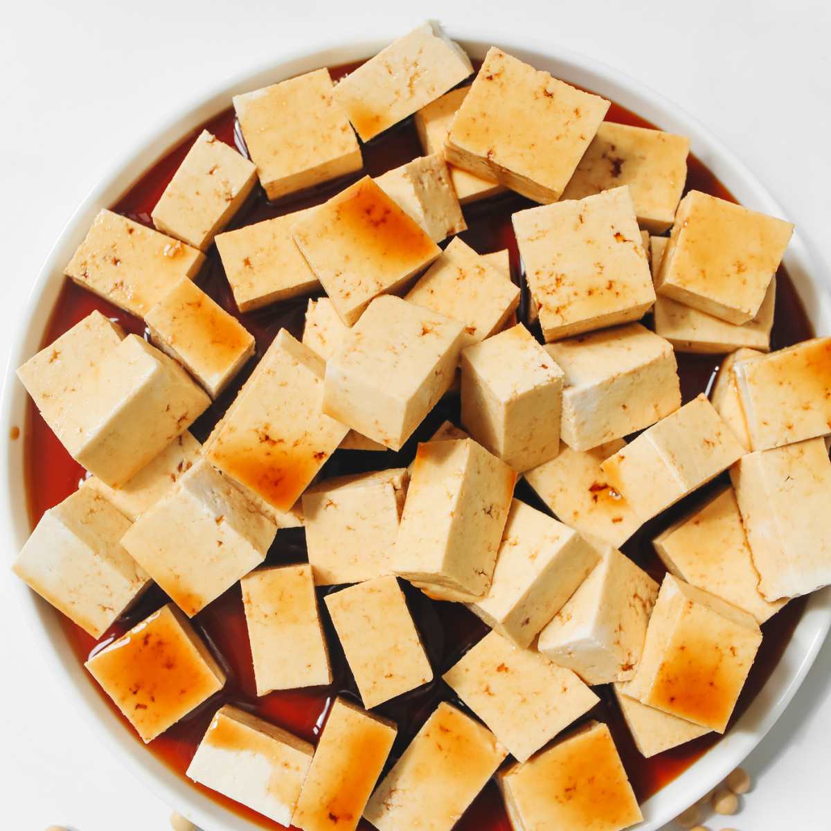 Cubed tofu marinating in coconut aminos.