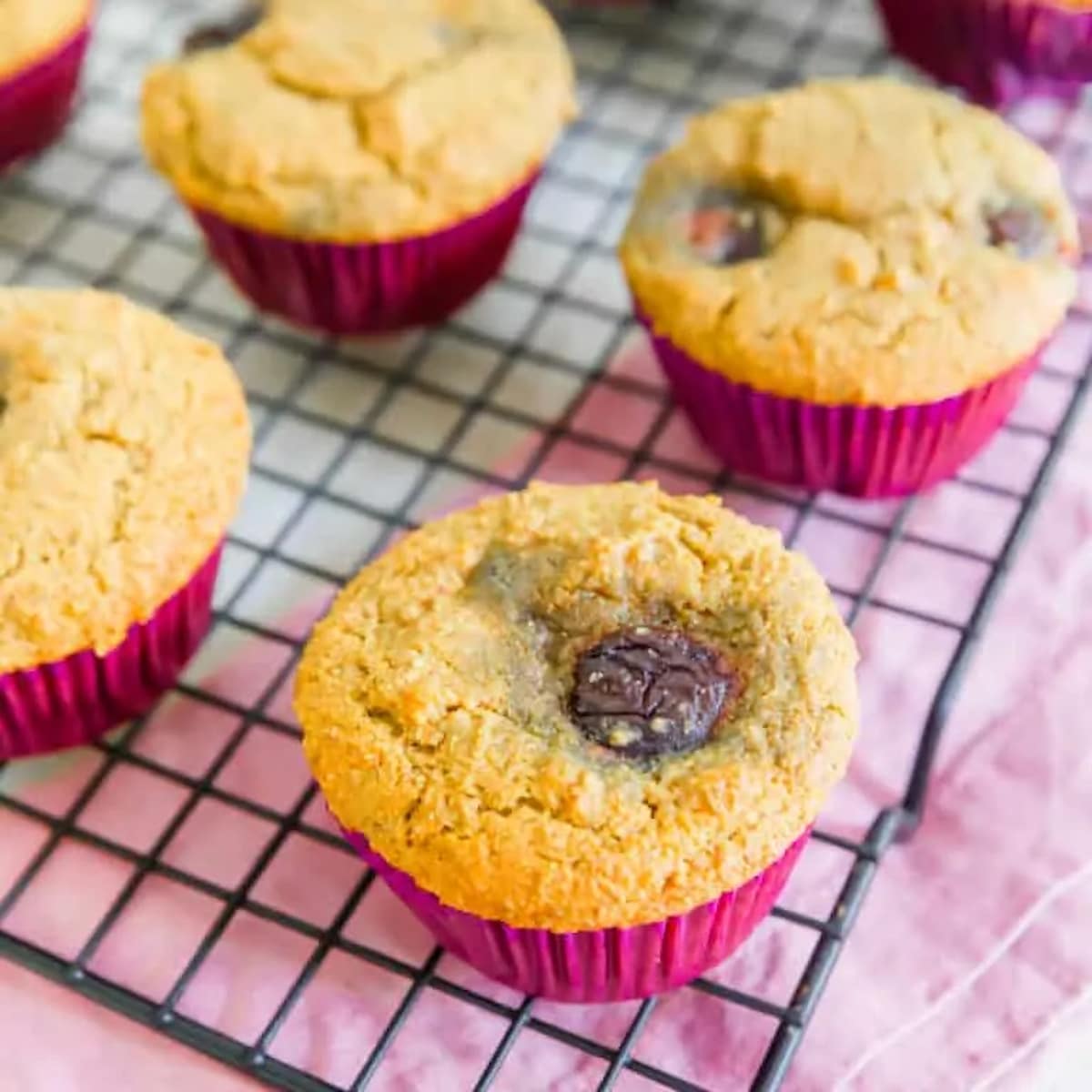 Vegan cherry cornmeal muffins on a cooling rack.