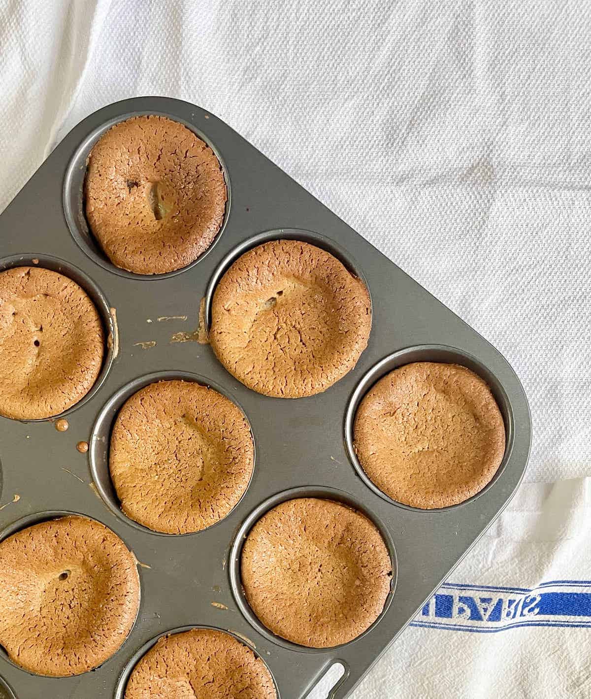 Vegan green tea mochi muffins in a muffin pan.