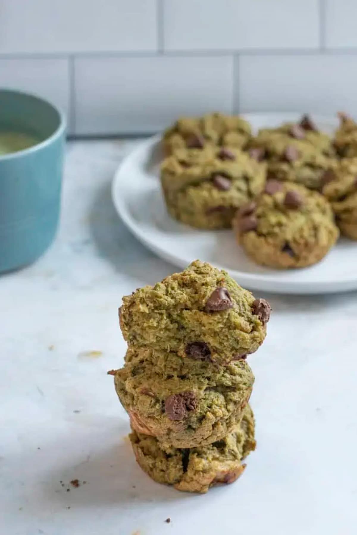 Vegan matcha muffins stacked on one another.