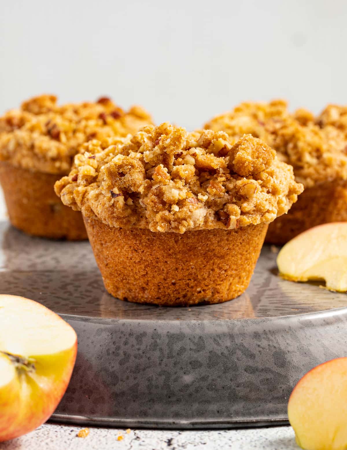 Vegan apple muffins topped with a crumb topping.