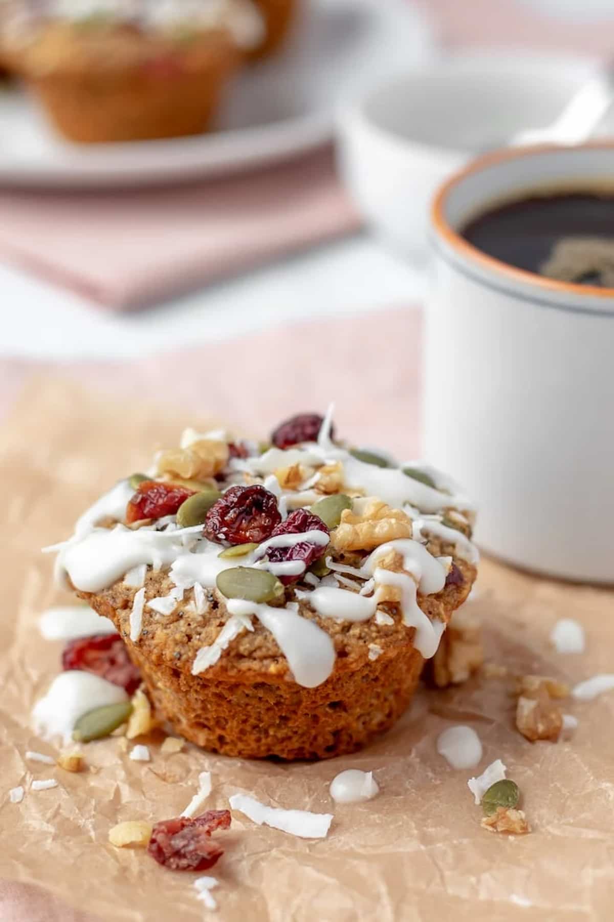 Oat flour muffins topped with a drizzle of coconut butter glaze, chopped nuts, and dried fruit.