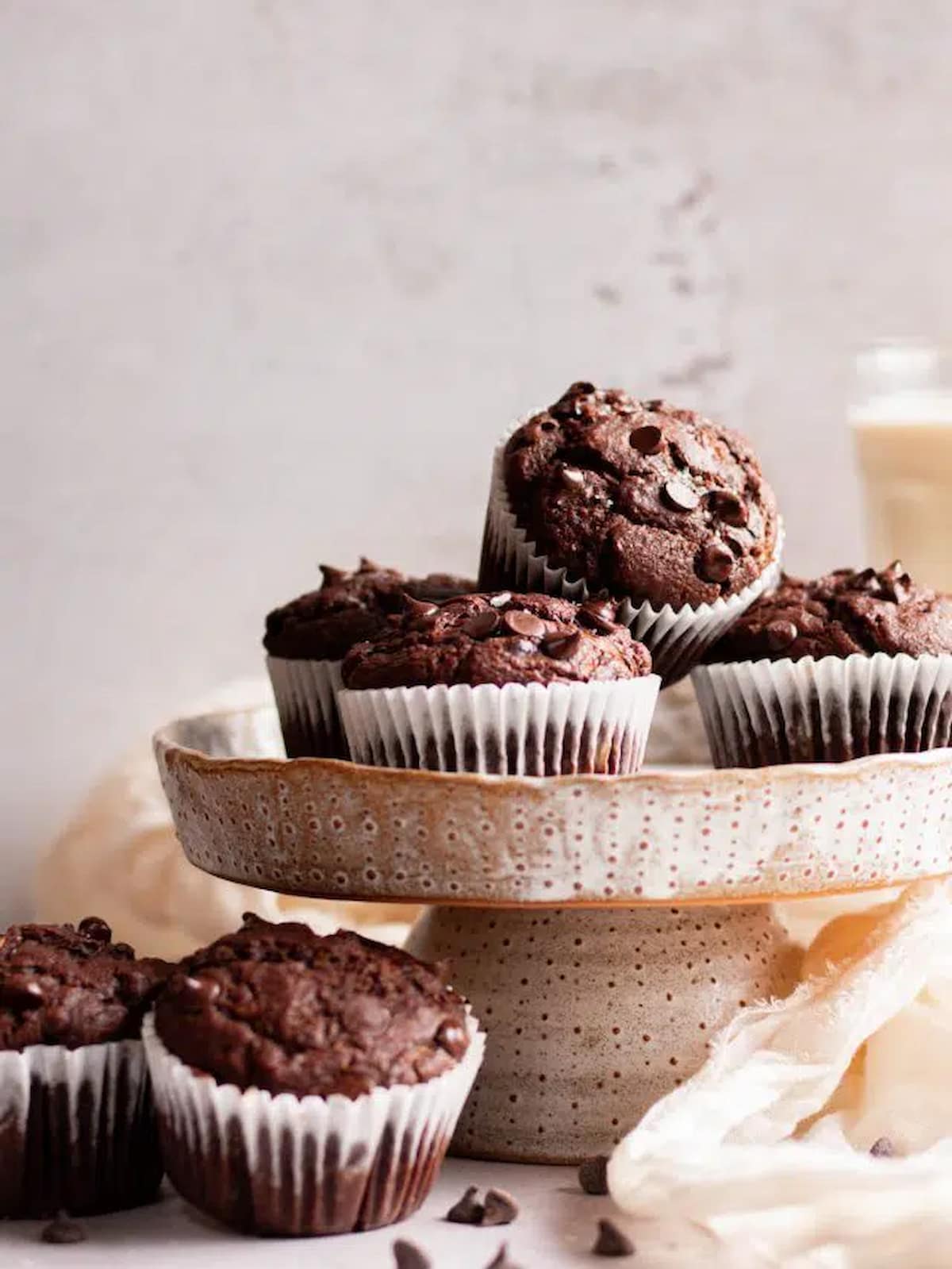 Vegan chocolate chip zucchini muffins on a cake platter.