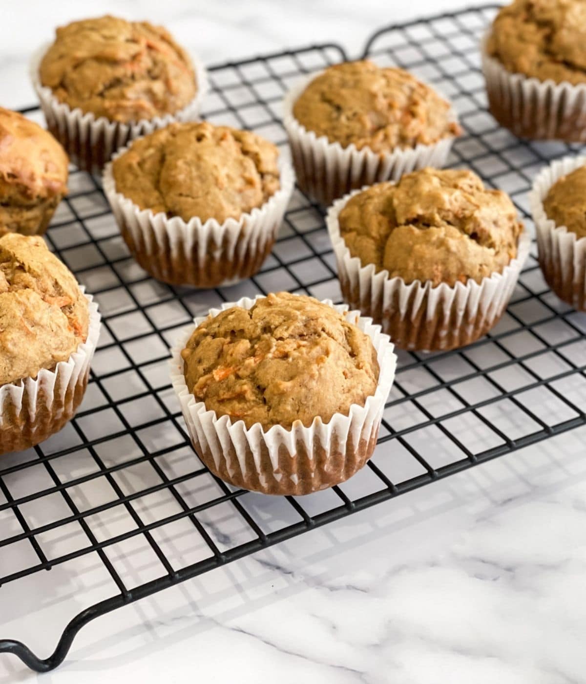 Vegan banana carrot muffins on a cooling rack.