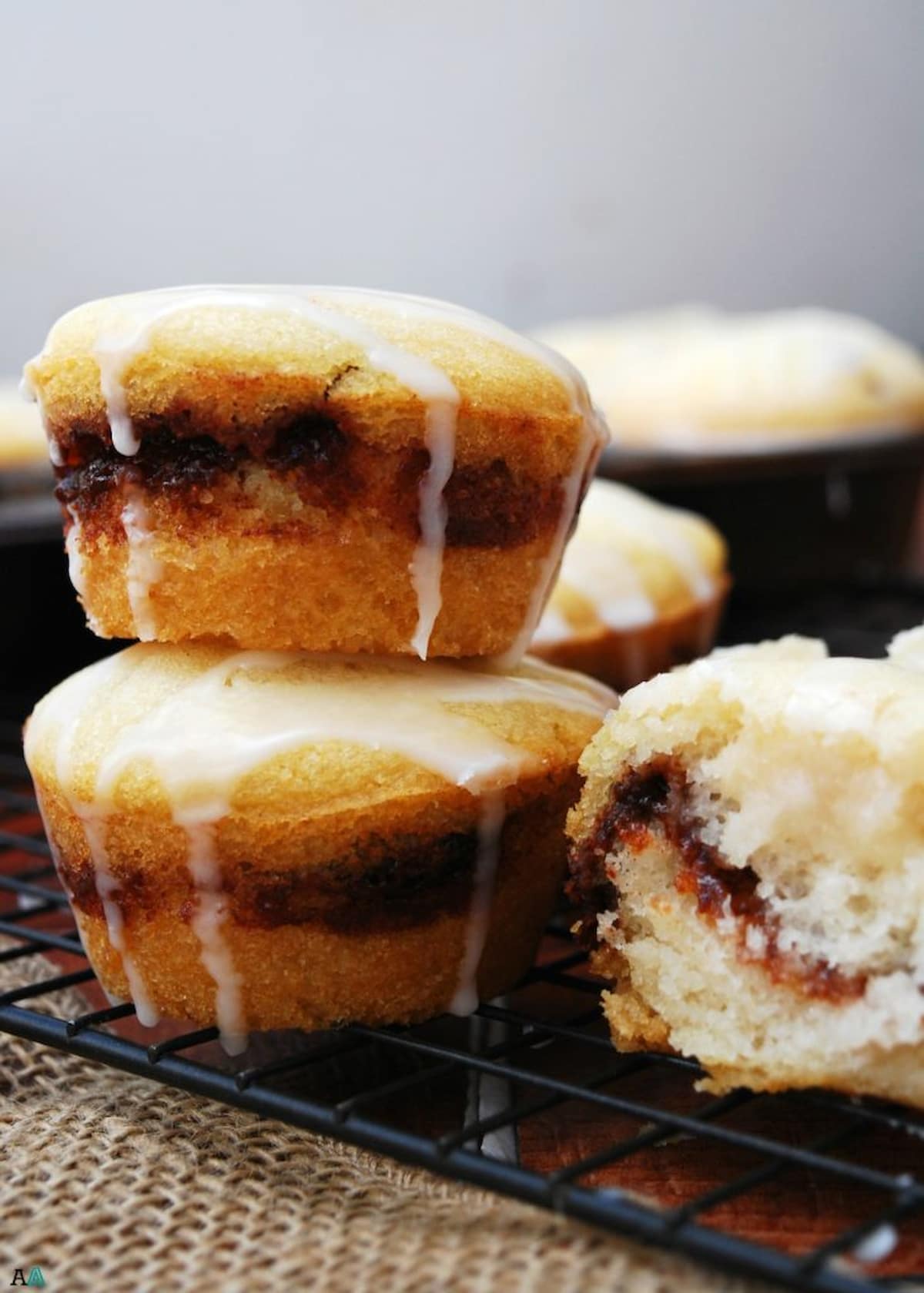 Vegan cinnamon swirl muffins with a sweet glaze on top.