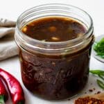 A mason jar filled with Korean BBQ sauce placed on a marble board.