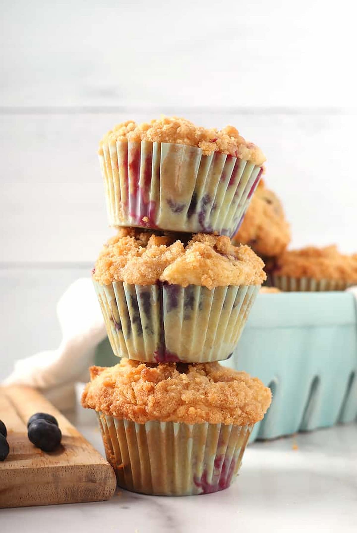 Three mixed berry muffins stacked on top of one another.