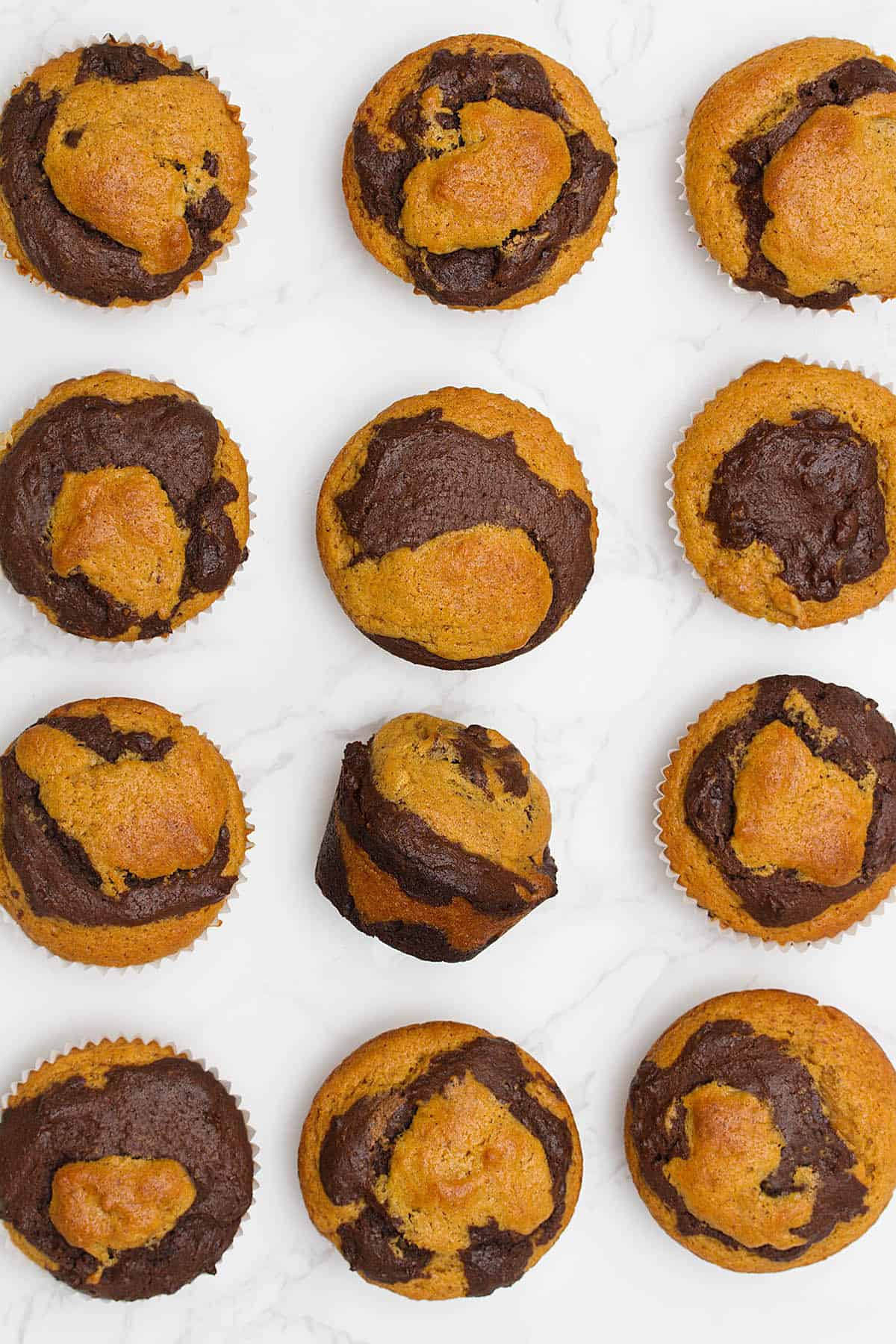 Pumpkin chocolate muffins in a row with some turned on their sides.