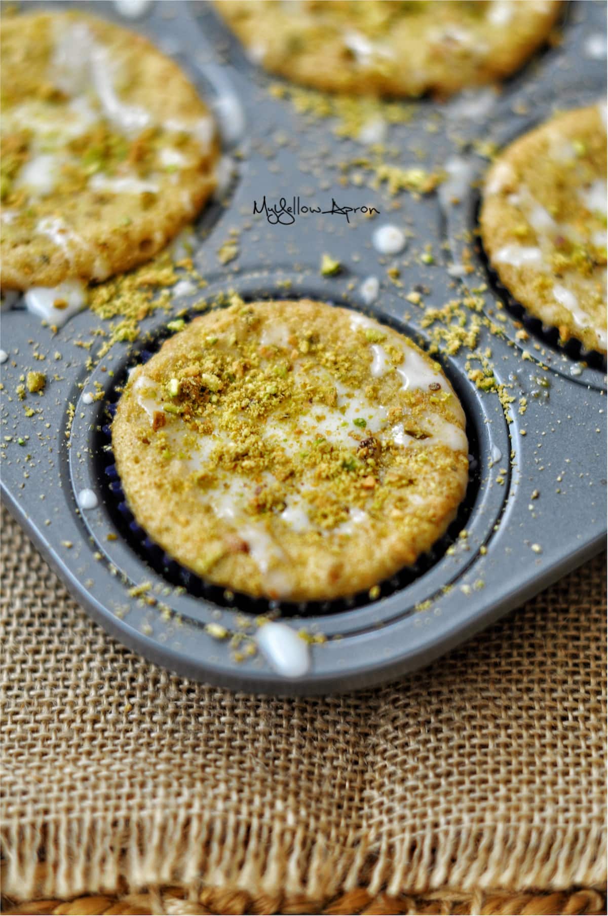 Vegan lemon pistachio muffins in a muffin pan.