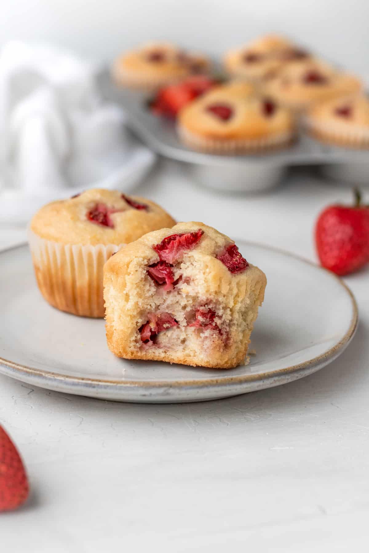 Two vegan strawberry muffins on a plate.