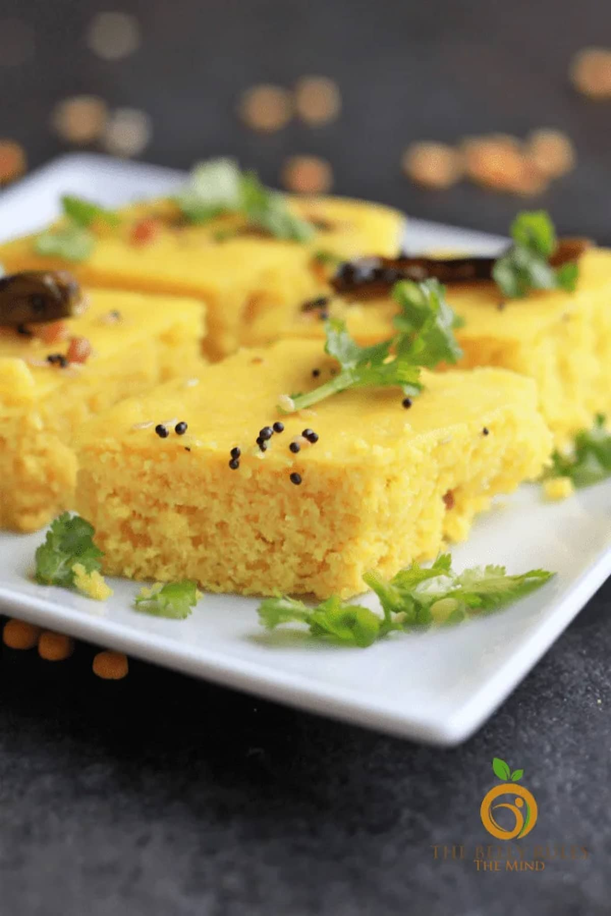 Khaman Dhokla cut in squares on a plate.