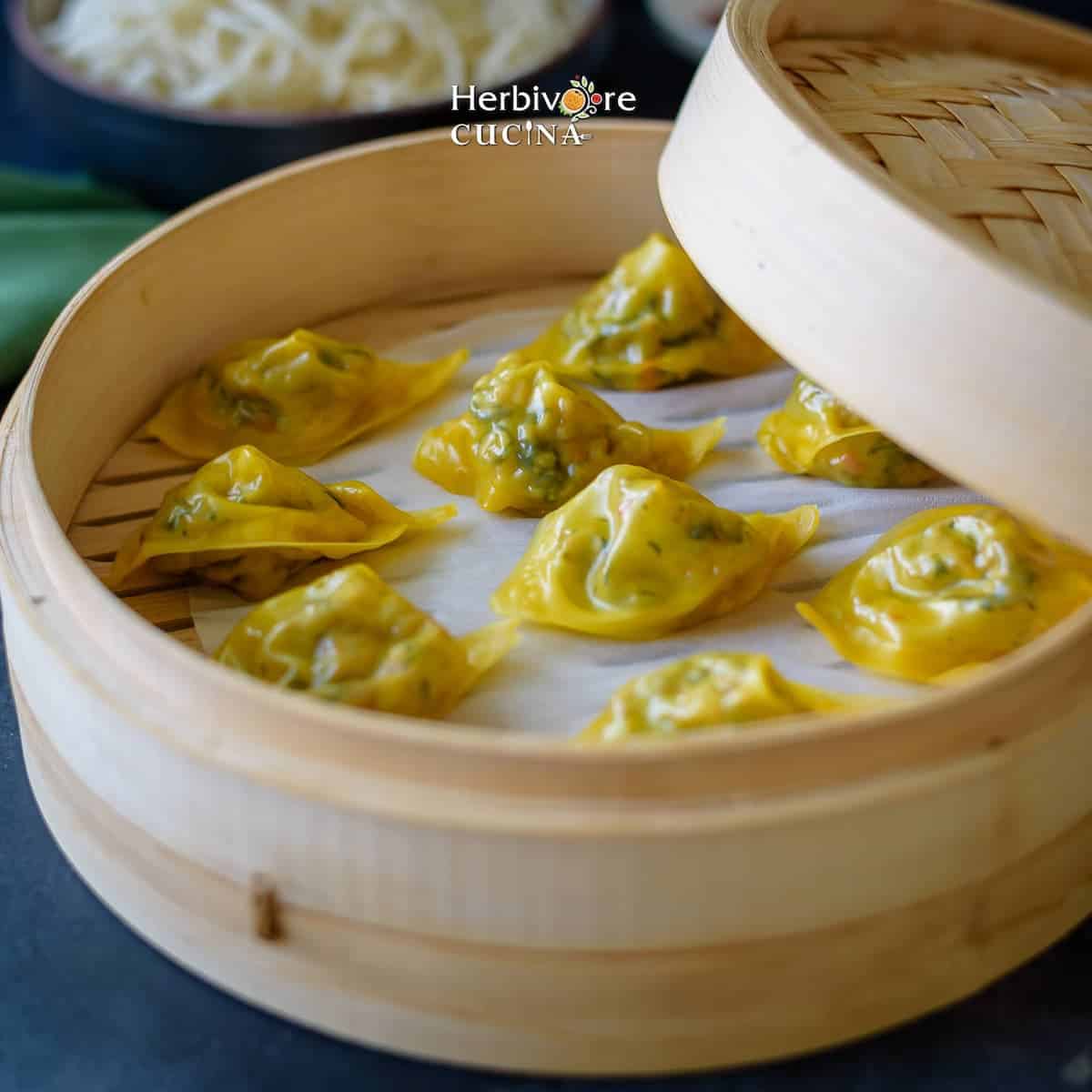 A bamboo steamer basket filled with steamed dumplings.