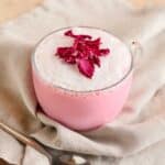 Rose latte in a clear glass mug.