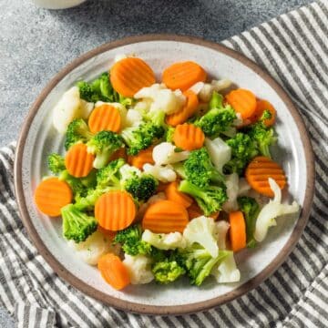 Steamed carrots, broccoli, and cauliflower on a plate.