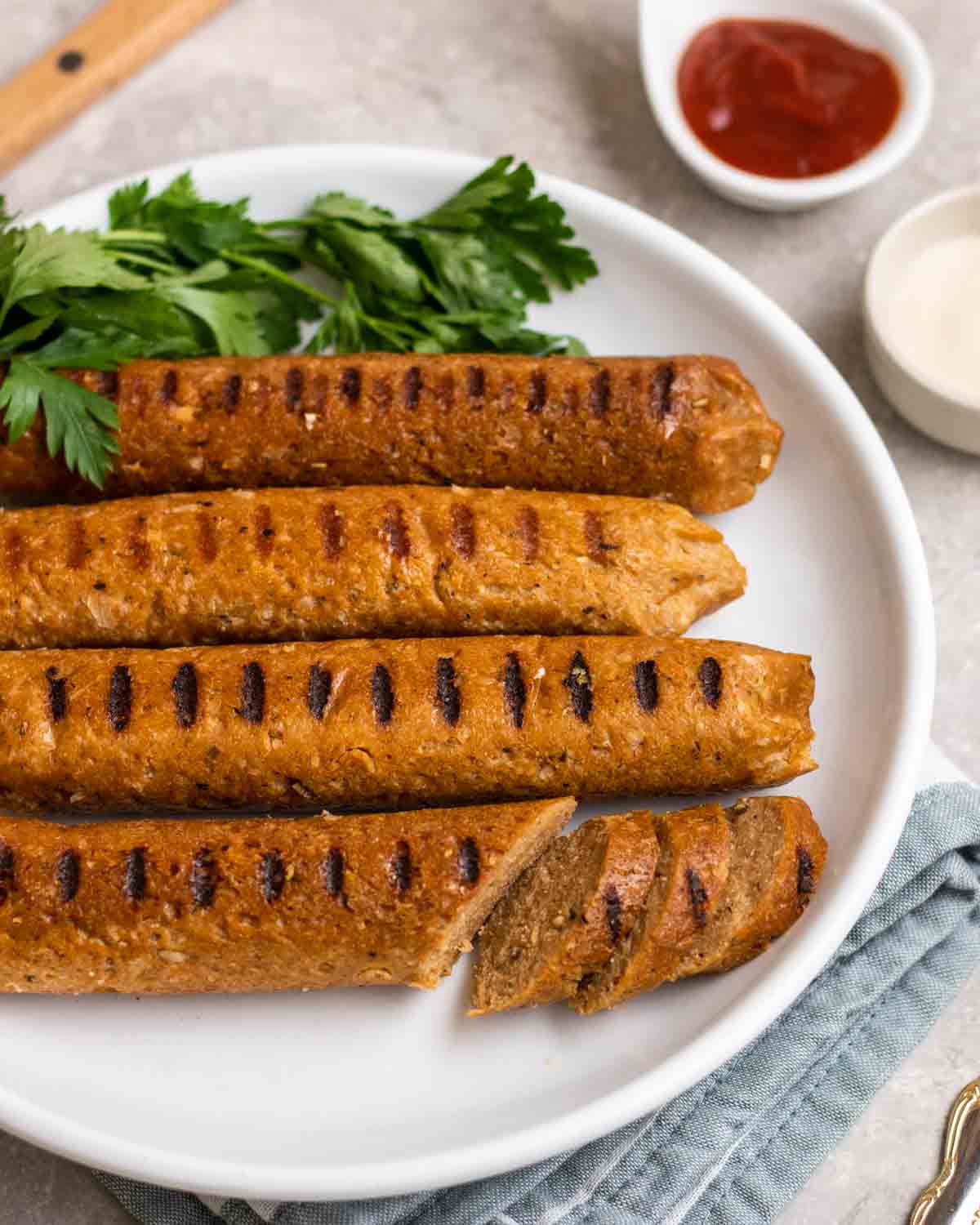 Four vegan Italian sausages on a plate.