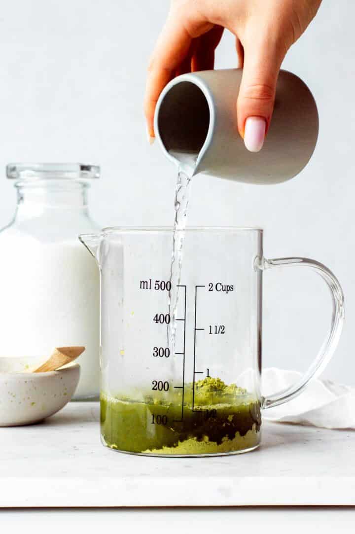 Pouring hot water over matcha powder.