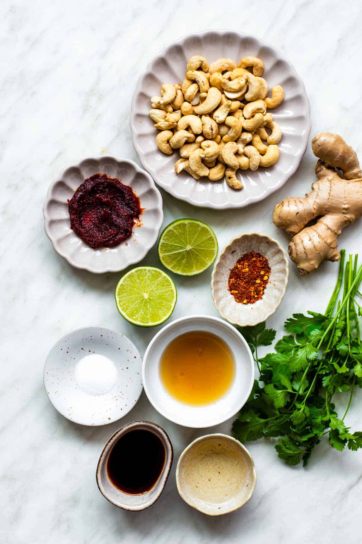 Gathered ingredients for spicy cashew dressing in various bowls.