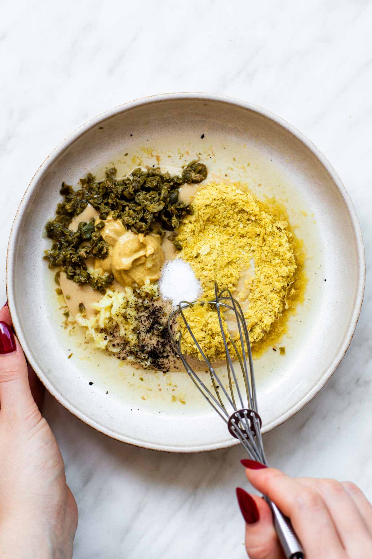 Combining the ingredients for this Tahini Caesar Dressing in a bowl.