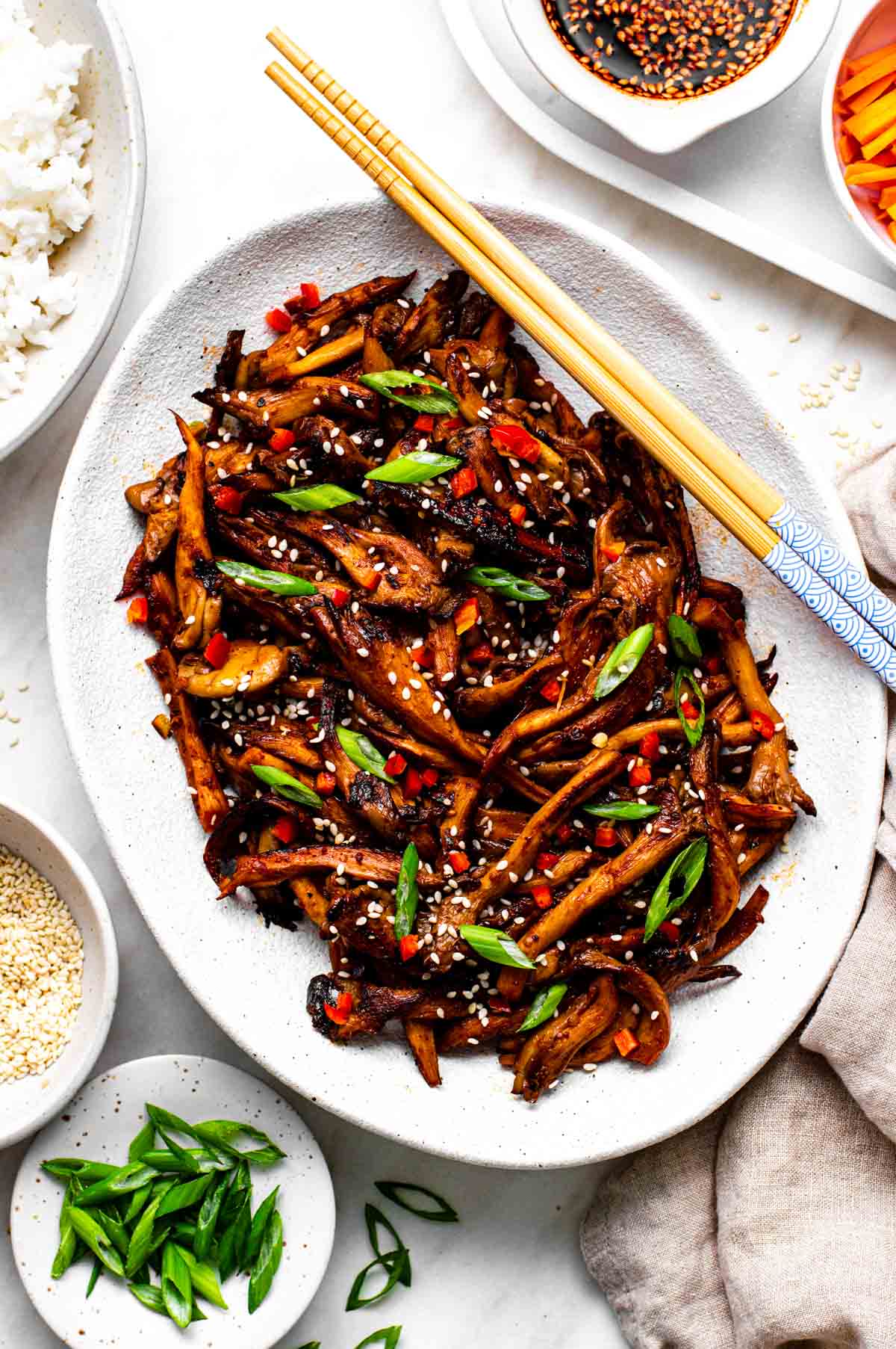 A platter of vegan bulgogi topped with sesame seeds and sliced green onion.