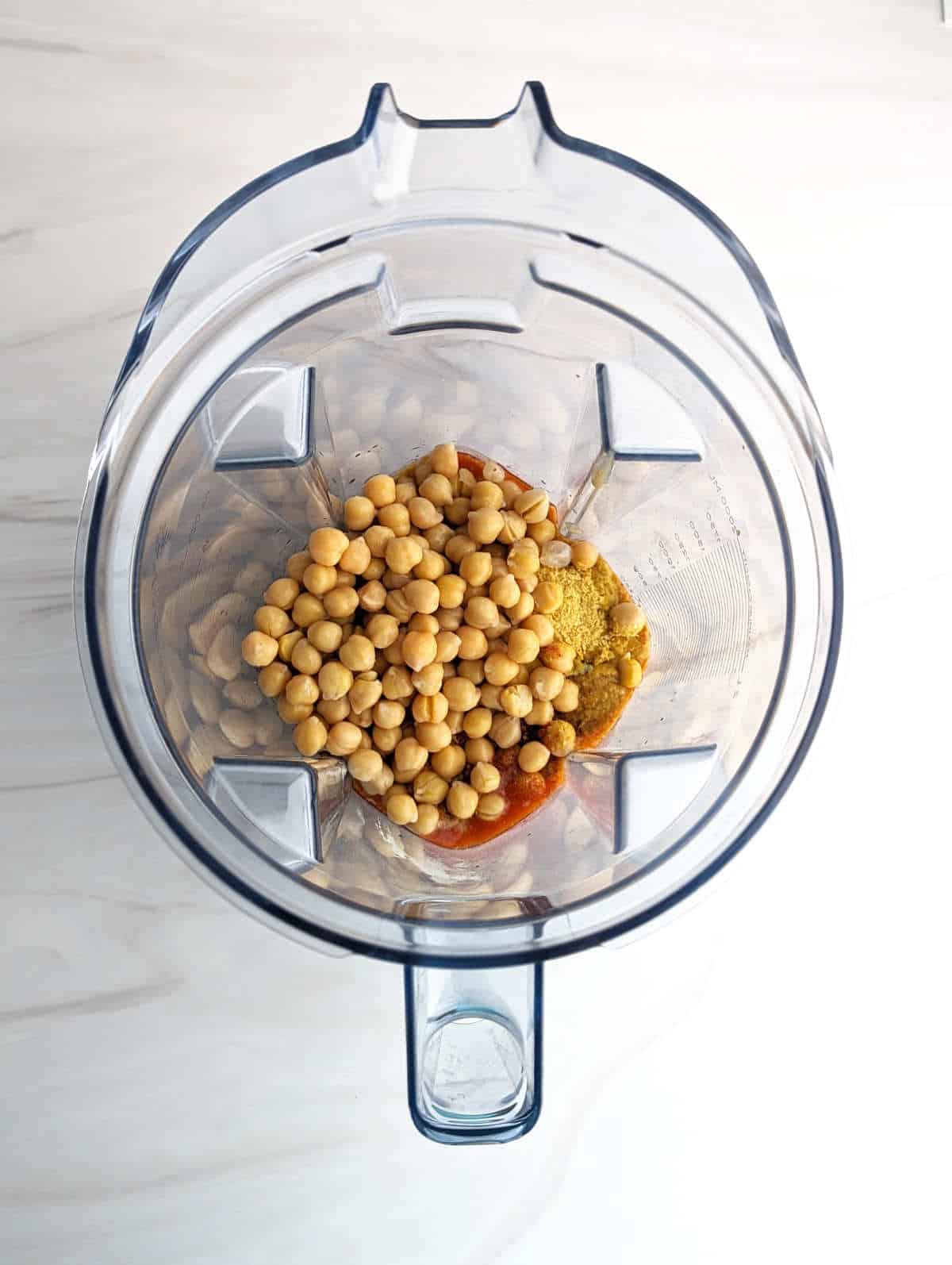 Ingredients for buffalo chickpea dip added to a blender pitcher.