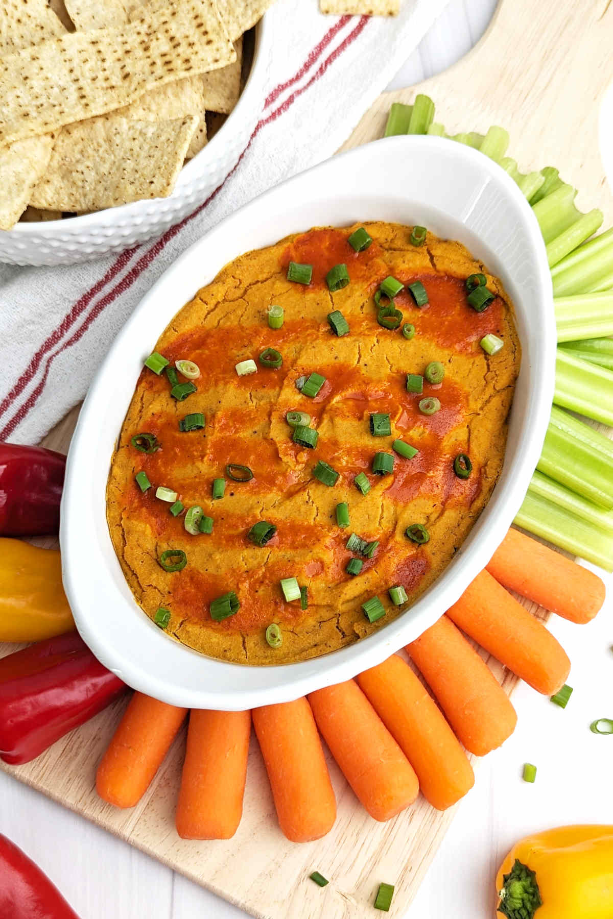 Buffalo chickpea dip served with a variety of fresh vegetable sticks.