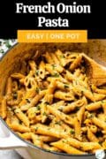 A Dutch oven of french onion pasta topped with thyme leaves with text overlay "French Onion Pasta easy one pot."