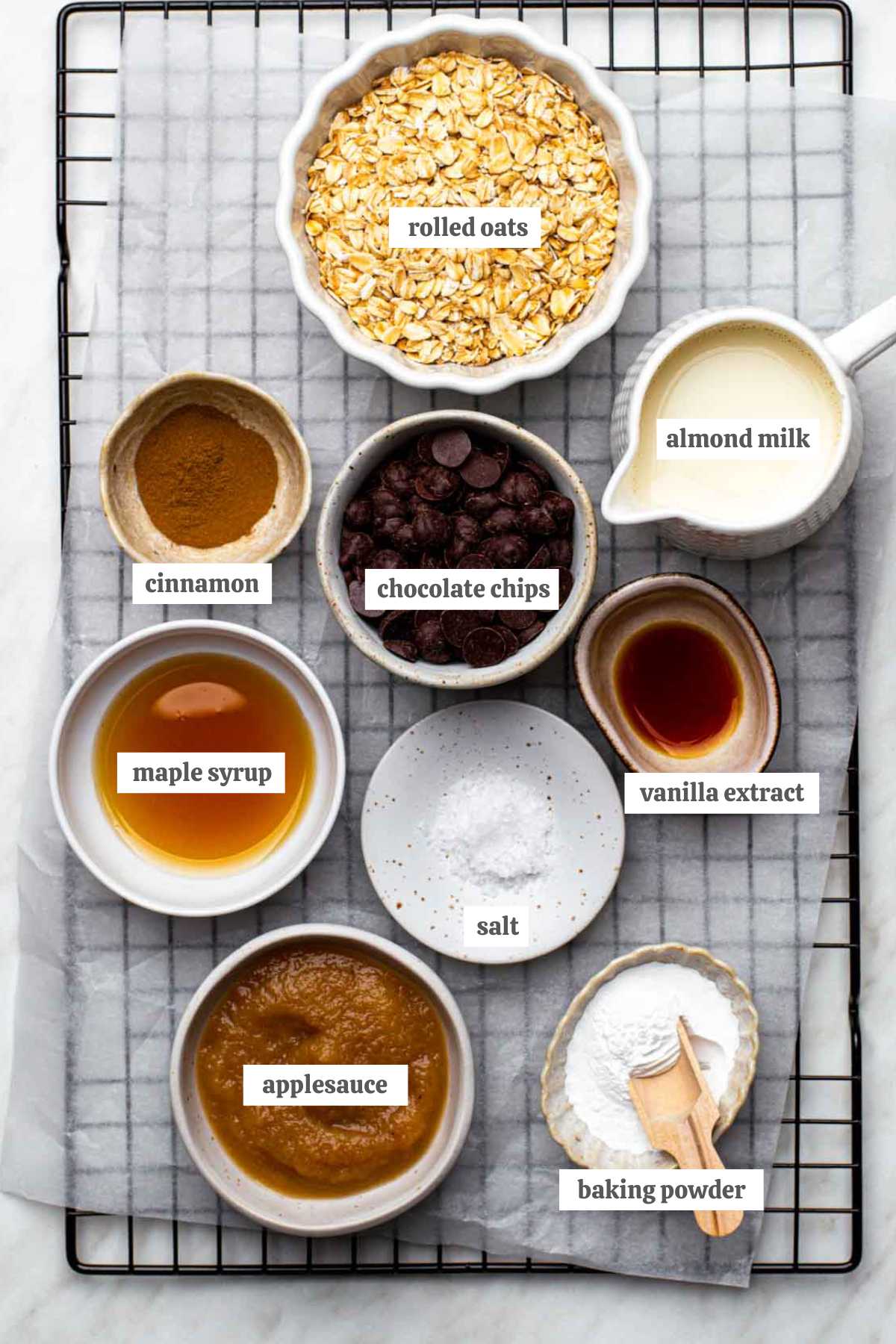 Gathered ingredients for this baked oats without banana recipe in various bowls with labels.