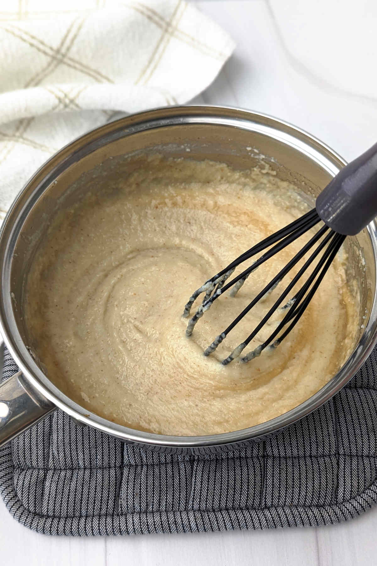 Whisking in the vanilla extract and maple syrup into the cream of wheat in a saucepan.