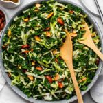Copycat Chick-fil-A kale crunch salad recipe in a bowl with wooden spoons for serving.