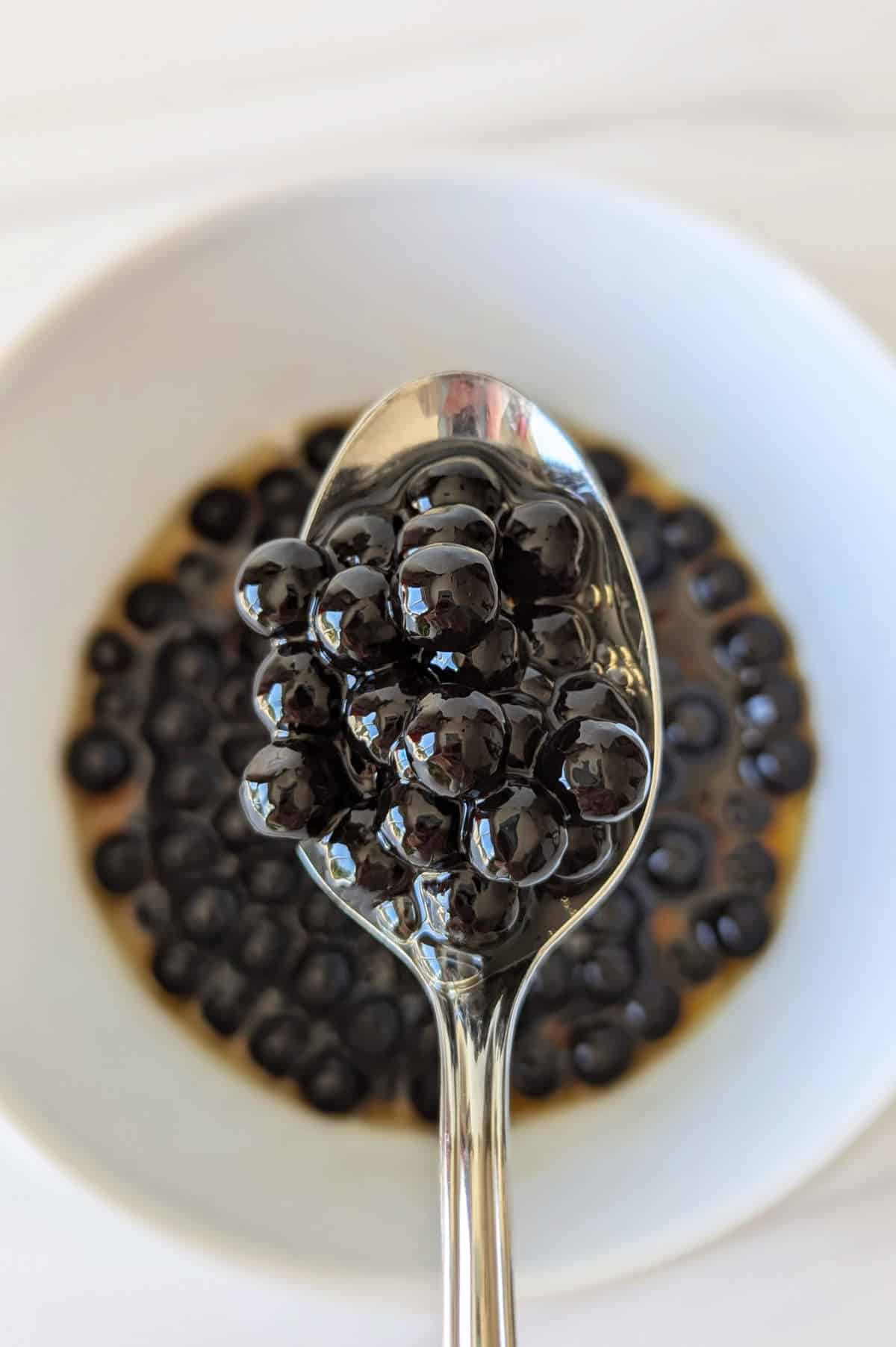 A spoonful of cooked boba pearls mixed with maple syrup.