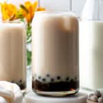 Jasmine milk tea with boba pearls in a tall glass.