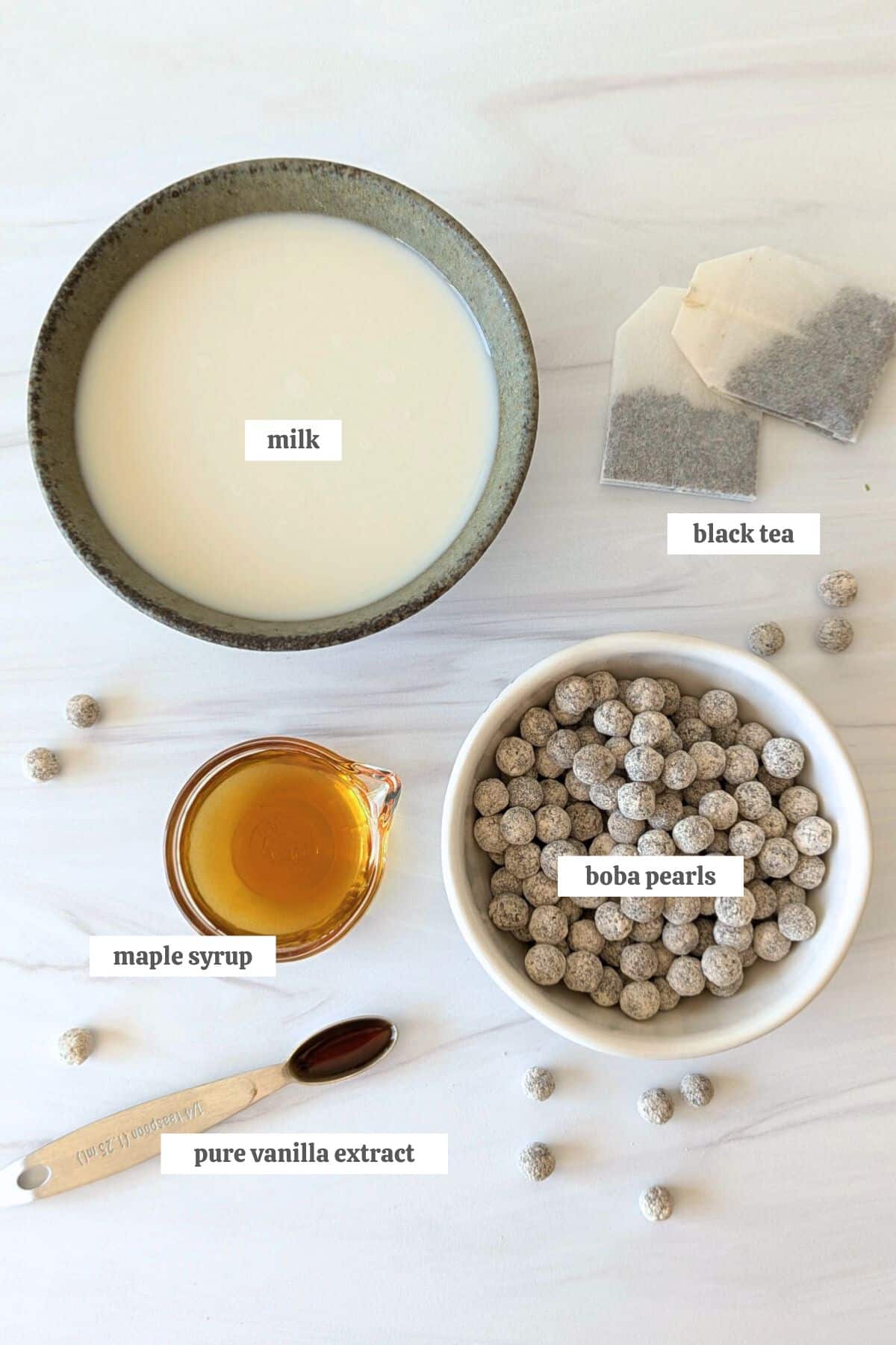 Gathered ingredients for this vanilla milk tea recipe measure out in bowls and labeled.