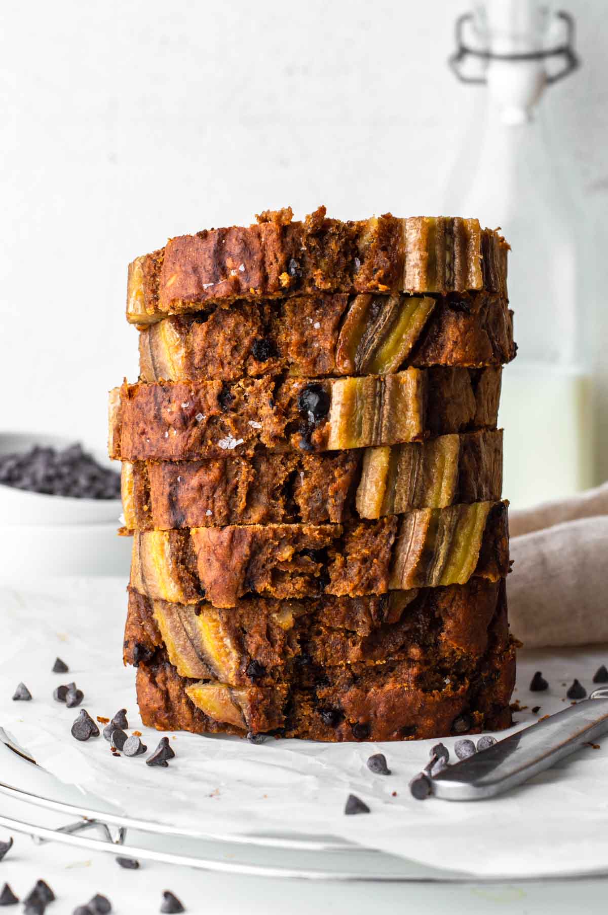 A stack of healthy banana bread slices sitting on parchment paper.