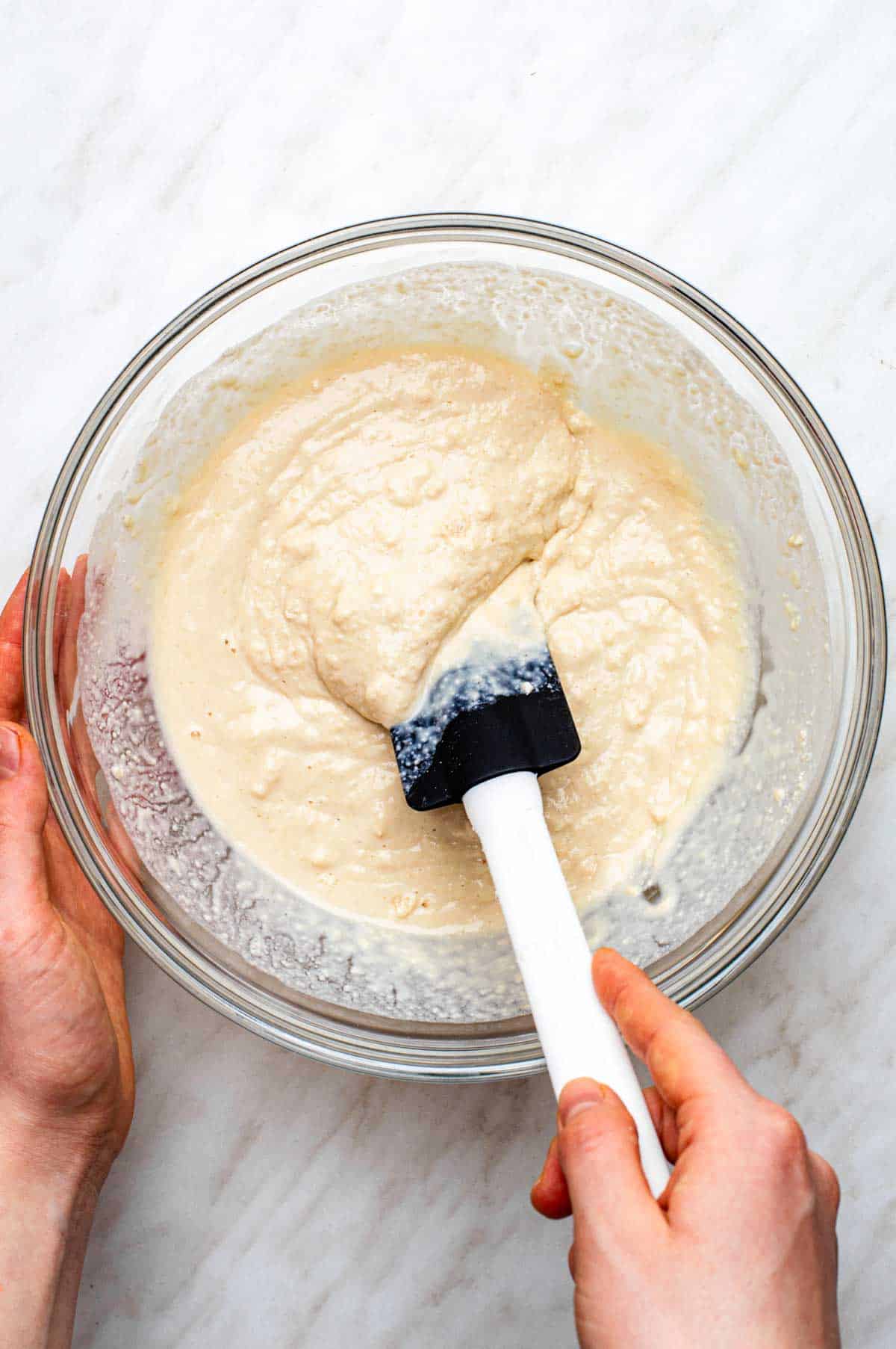 The batter for vegan bisquick pancakes mixed together in a both with a silicone spatula.